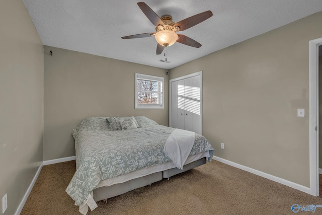 carpeted bedroom featuring ceiling fan and a textured ceiling