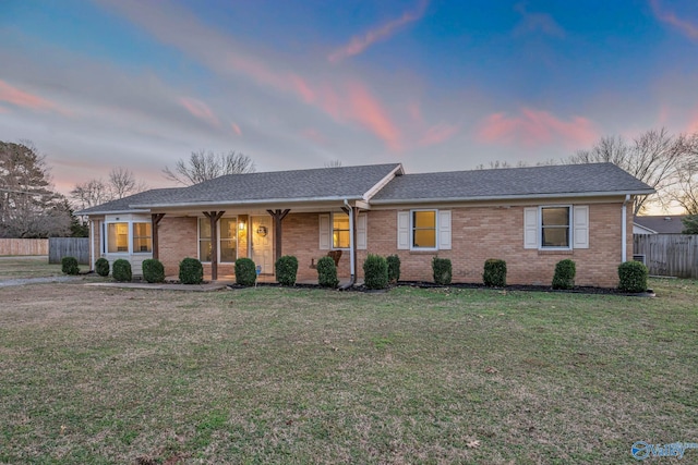 single story home featuring a lawn