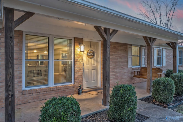 exterior entry at dusk featuring covered porch