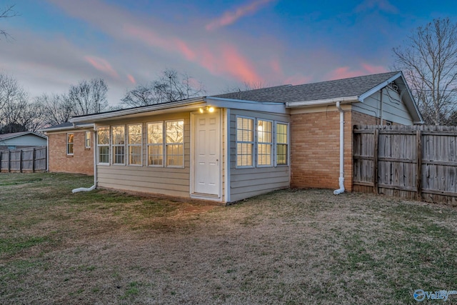 outdoor structure at dusk featuring a yard