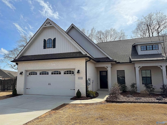 view of front of home featuring a shingled roof, brick siding, driveway, and fence