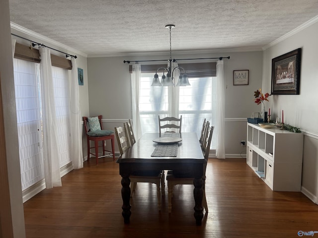 dining space with dark wood-type flooring, crown molding, a textured ceiling, and a notable chandelier