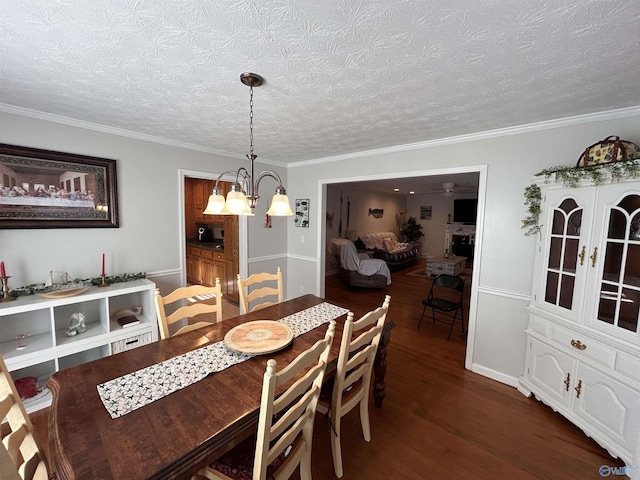 dining area with crown molding, dark hardwood / wood-style floors, a notable chandelier, and a textured ceiling