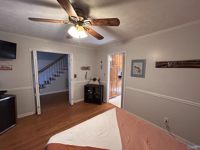 bedroom with crown molding, ceiling fan, hardwood / wood-style floors, and a textured ceiling