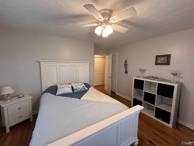 bedroom featuring ceiling fan, dark hardwood / wood-style floors, a textured ceiling, and a closet