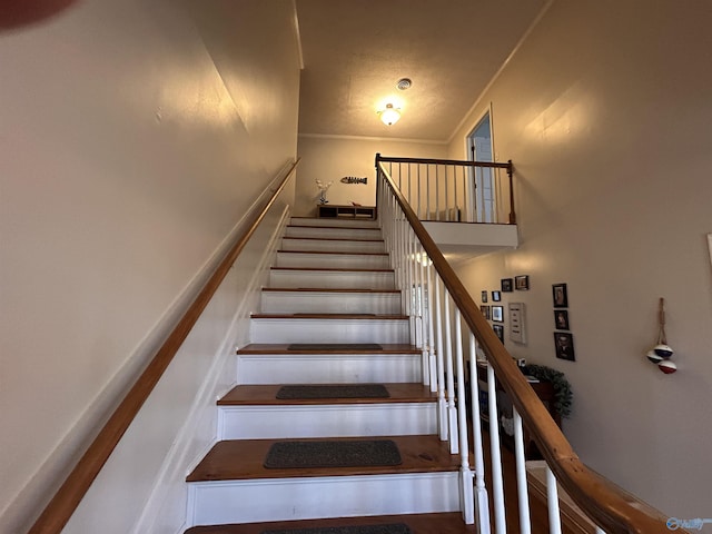 staircase featuring ornamental molding