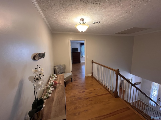 hall with crown molding, hardwood / wood-style floors, and a textured ceiling