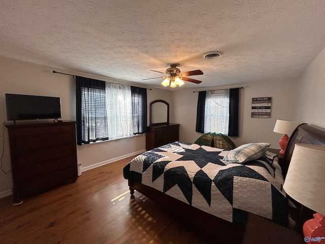 bedroom featuring dark hardwood / wood-style floors, a textured ceiling, and ceiling fan