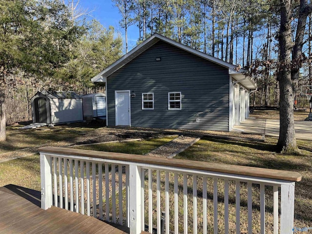 back of house with a deck and a storage unit