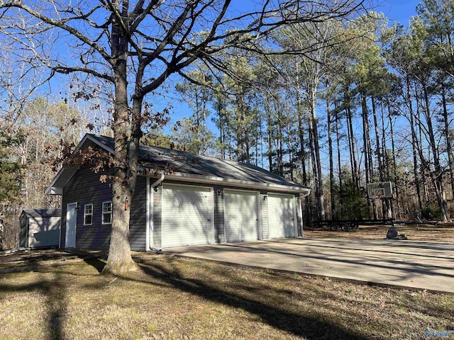 view of side of home with a garage, a yard, and an outbuilding