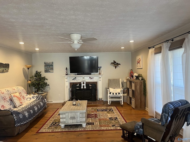 living room featuring ornamental molding, ceiling fan, a textured ceiling, and dark hardwood / wood-style flooring