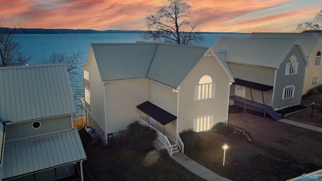 exterior space featuring a water view and metal roof