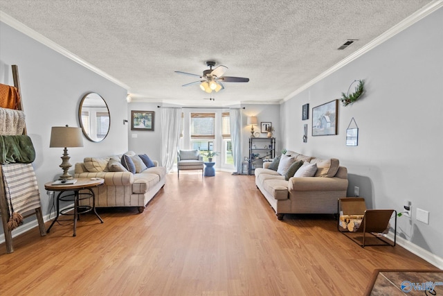 living room featuring crown molding, ceiling fan, light hardwood / wood-style floors, and a textured ceiling