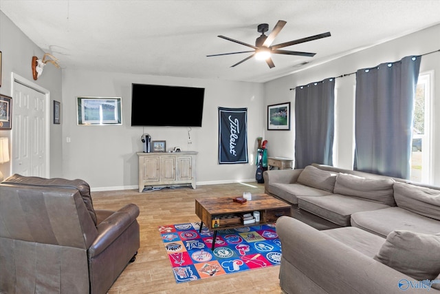 living room featuring ceiling fan and light hardwood / wood-style flooring