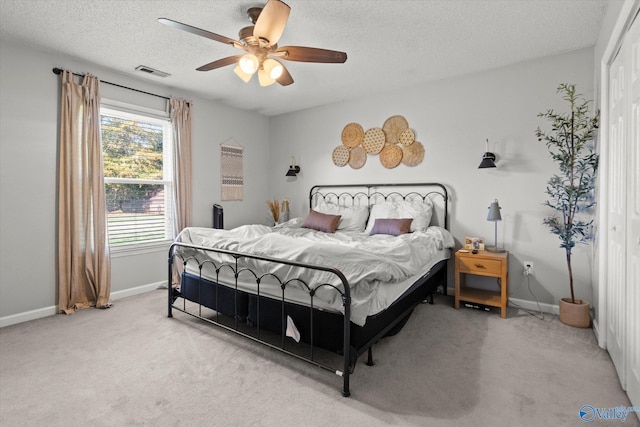 bedroom with light carpet, a textured ceiling, a closet, and ceiling fan