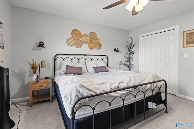 bedroom featuring ceiling fan, light carpet, and a closet