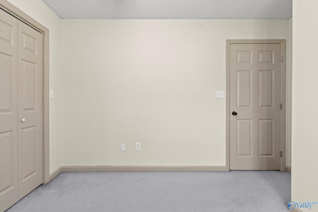 carpeted empty room with a textured ceiling