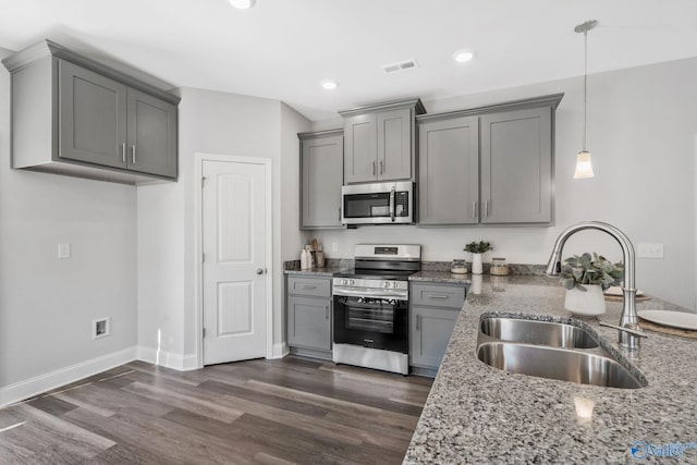 kitchen featuring visible vents, appliances with stainless steel finishes, light stone counters, gray cabinetry, and a sink