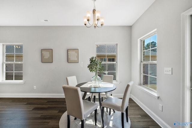 dining area featuring dark wood-style floors, visible vents, baseboards, and a chandelier