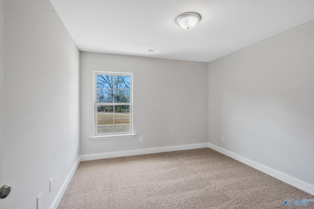 carpeted spare room with visible vents and baseboards