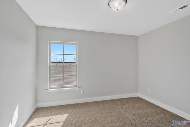 empty room featuring light colored carpet, visible vents, and baseboards