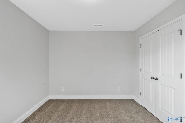 unfurnished bedroom with carpet, visible vents, and baseboards