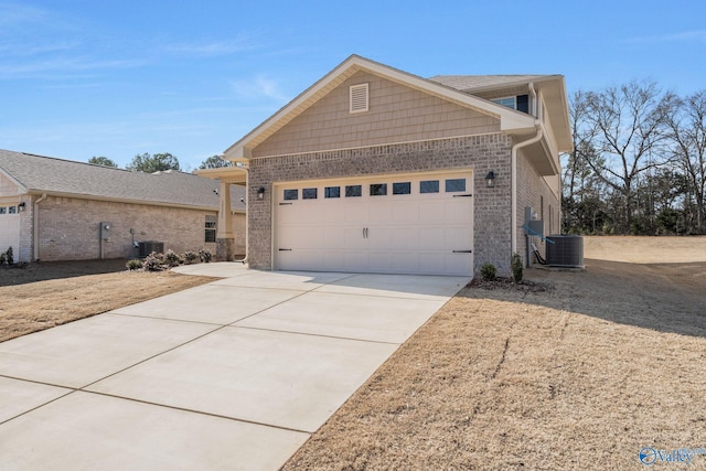 view of front of property featuring a garage, driveway, brick siding, and central AC unit