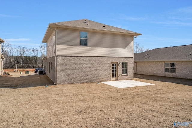 rear view of house with a patio area and brick siding