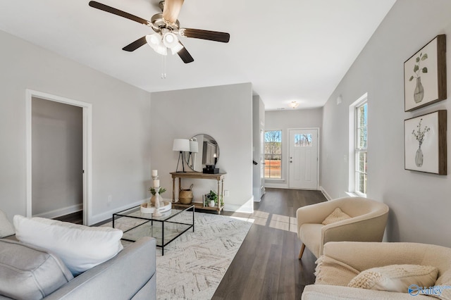 living area with ceiling fan, baseboards, and wood finished floors