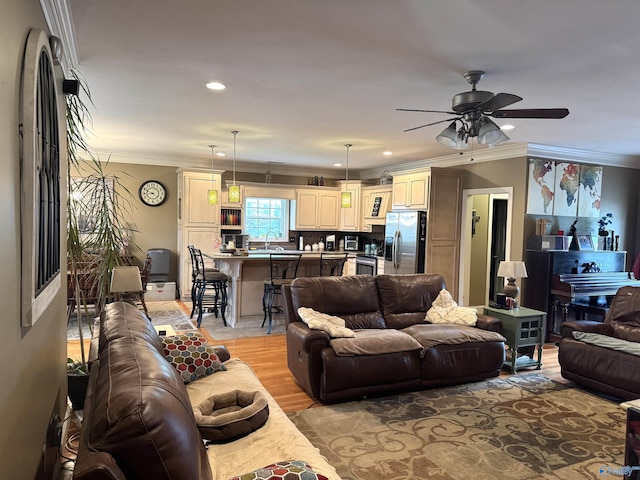 living room with ceiling fan, recessed lighting, light wood-style flooring, and crown molding