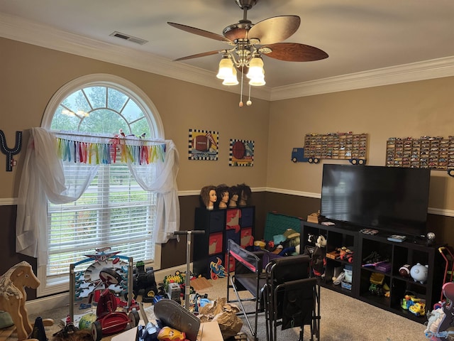playroom featuring carpet flooring, ceiling fan, ornamental molding, and visible vents