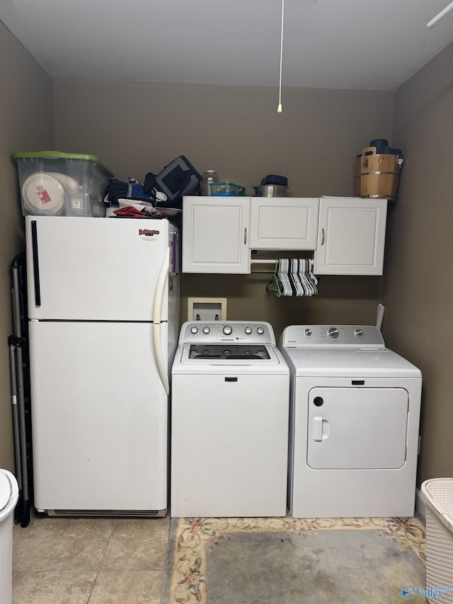 clothes washing area with washing machine and dryer and cabinet space