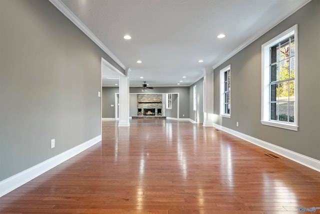 unfurnished living room with a fireplace, ceiling fan, light hardwood / wood-style flooring, and ornamental molding