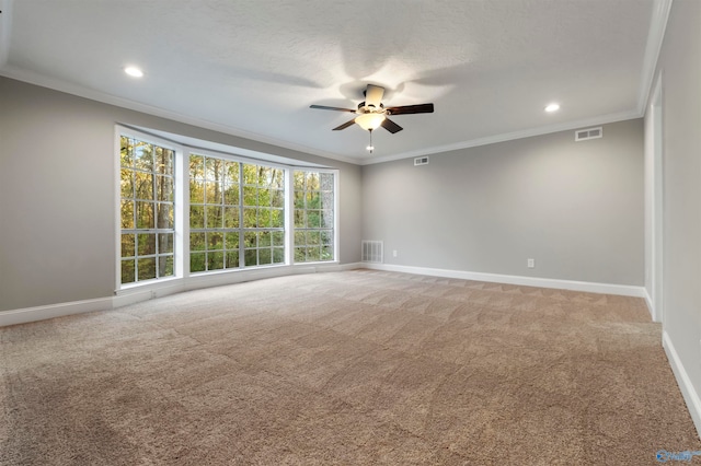 carpeted empty room featuring a textured ceiling, ceiling fan, and crown molding