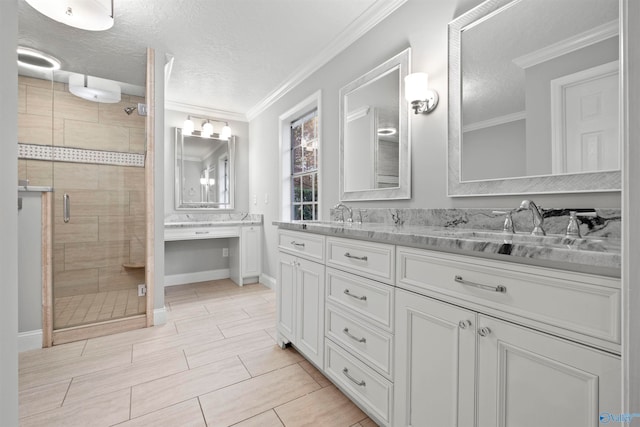 bathroom with vanity, ornamental molding, a textured ceiling, and a shower with shower door