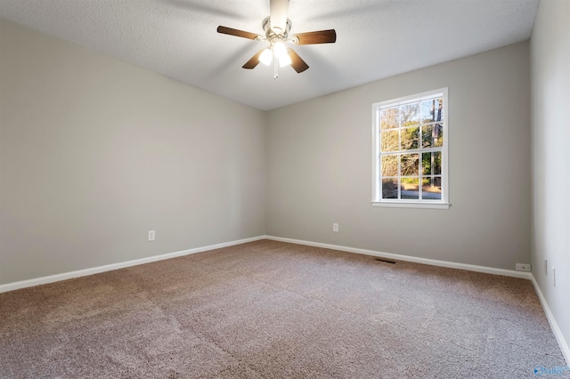 unfurnished room with ceiling fan, carpet floors, and a textured ceiling