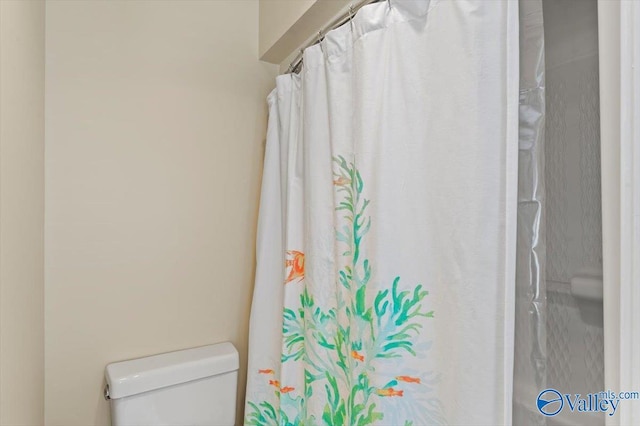 full bathroom with curtained shower and toilet
