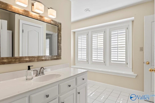 bathroom with baseboards, vanity, and tile patterned flooring