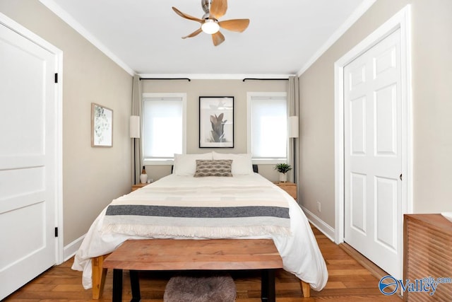 bedroom featuring baseboards, wood finished floors, ornamental molding, and ceiling fan