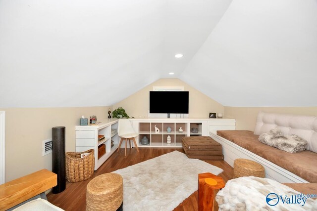 living room with vaulted ceiling, wood finished floors, visible vents, and recessed lighting