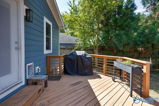 wooden terrace with a grill and fence