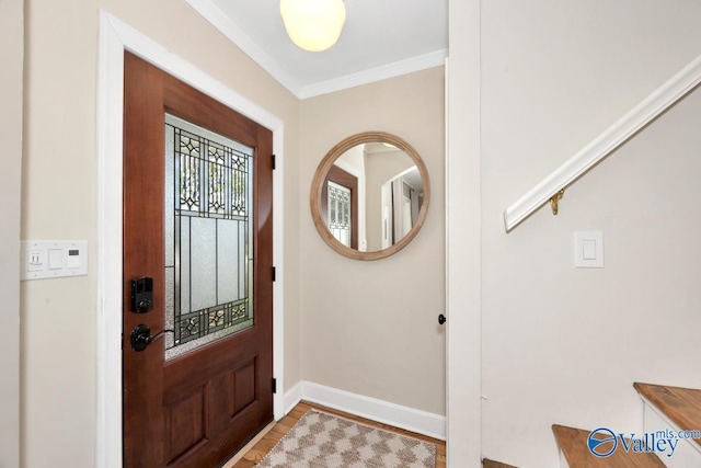 entrance foyer with wood finished floors, baseboards, and crown molding