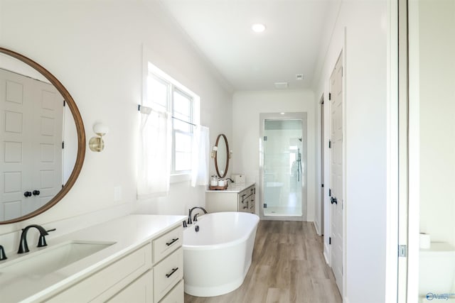 bathroom with shower with separate bathtub, vanity, and hardwood / wood-style floors