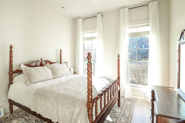 bedroom with wood-type flooring and multiple windows