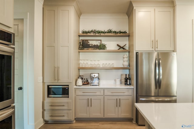 bar featuring light hardwood / wood-style flooring and appliances with stainless steel finishes