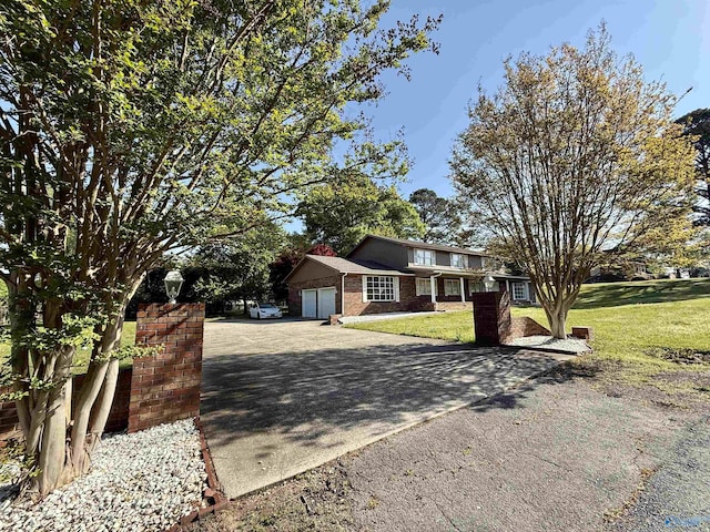 view of front facade featuring a front yard, an attached garage, brick siding, and concrete driveway