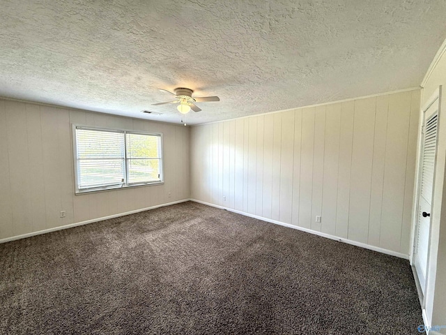 unfurnished room featuring carpet flooring, visible vents, a textured ceiling, and ceiling fan