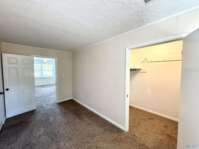 unfurnished bedroom with a textured ceiling, baseboards, ornamental molding, and carpet floors