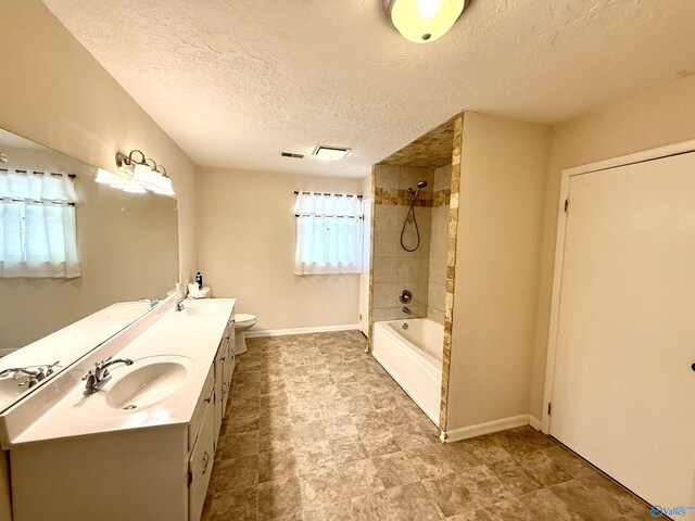 bathroom featuring baseboards, a sink, a textured ceiling, double vanity, and bathing tub / shower combination