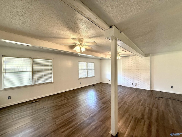 spare room featuring visible vents, baseboards, ceiling fan, dark wood finished floors, and a textured ceiling